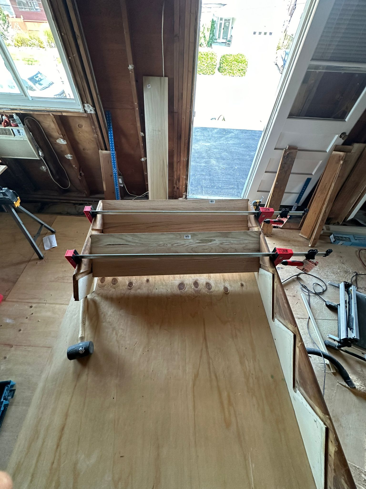A wooden clamp is sitting on top of a wooden table in a room.