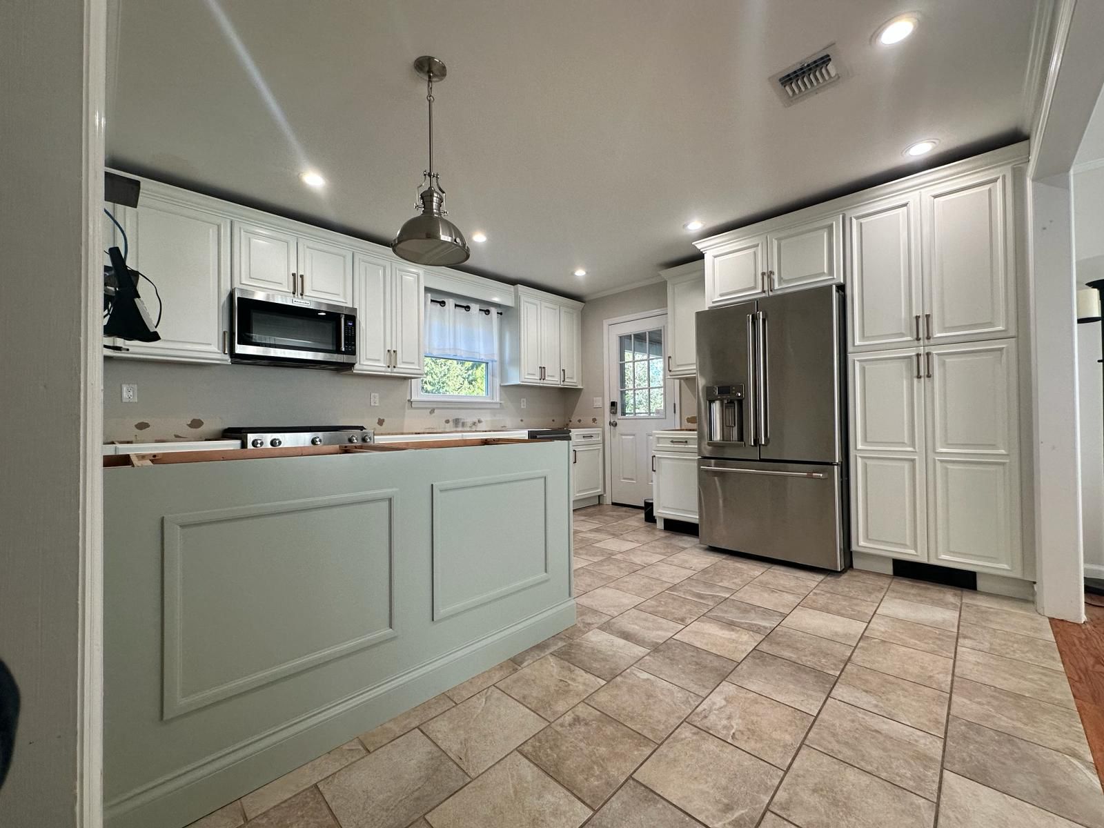 A kitchen with white cabinets and stainless steel appliances.