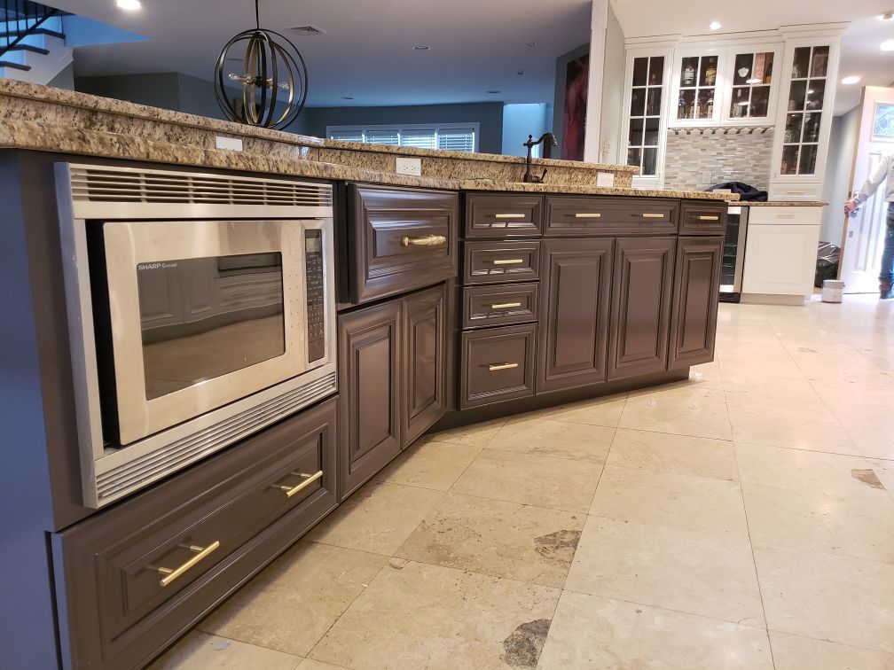 A kitchen with gray cabinets and stainless steel appliances.