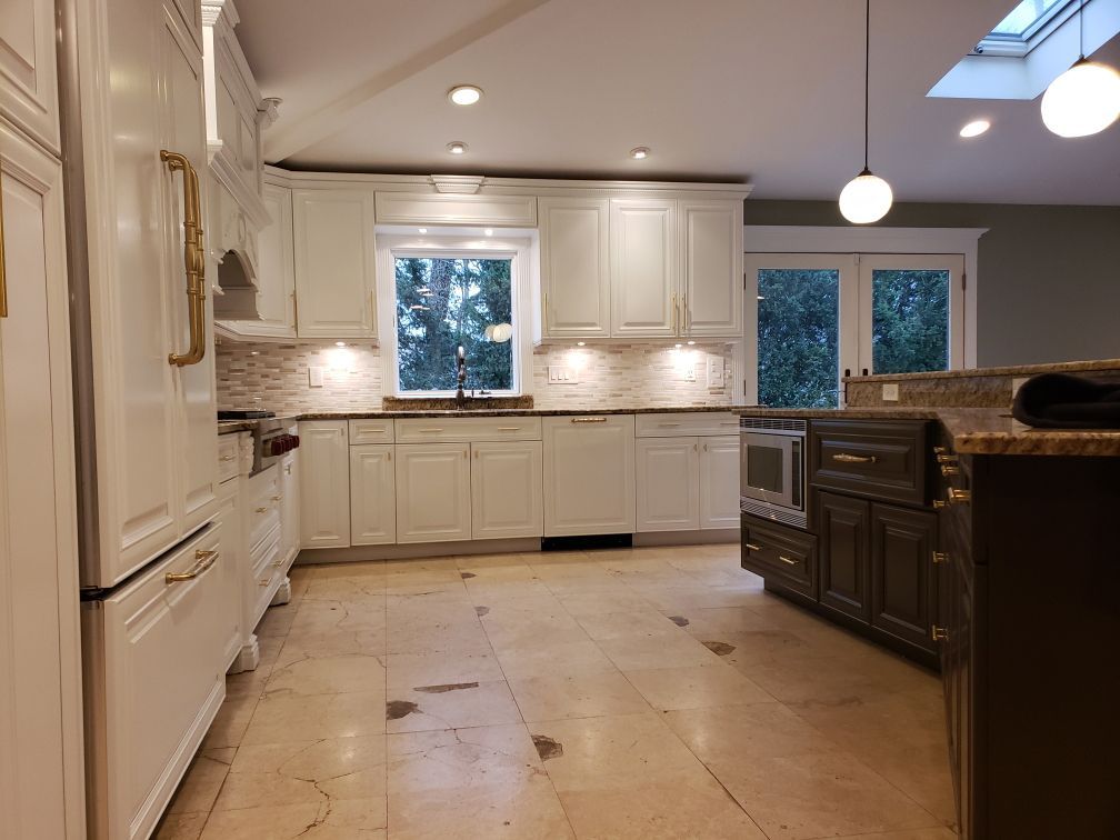 A kitchen with white cabinets and granite counter tops.
