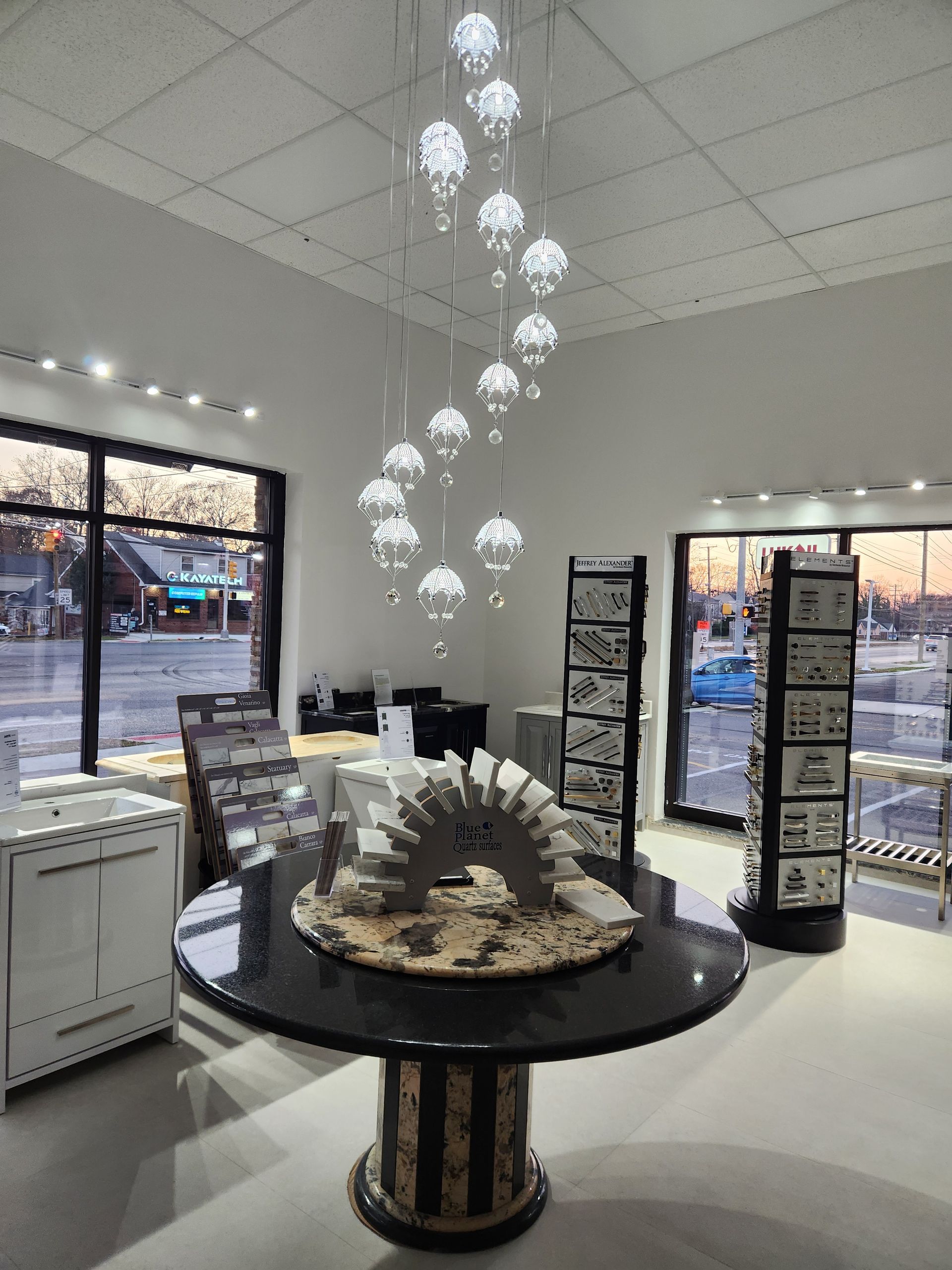 Showroom with a large circular table, decorative lighting, and display shelves