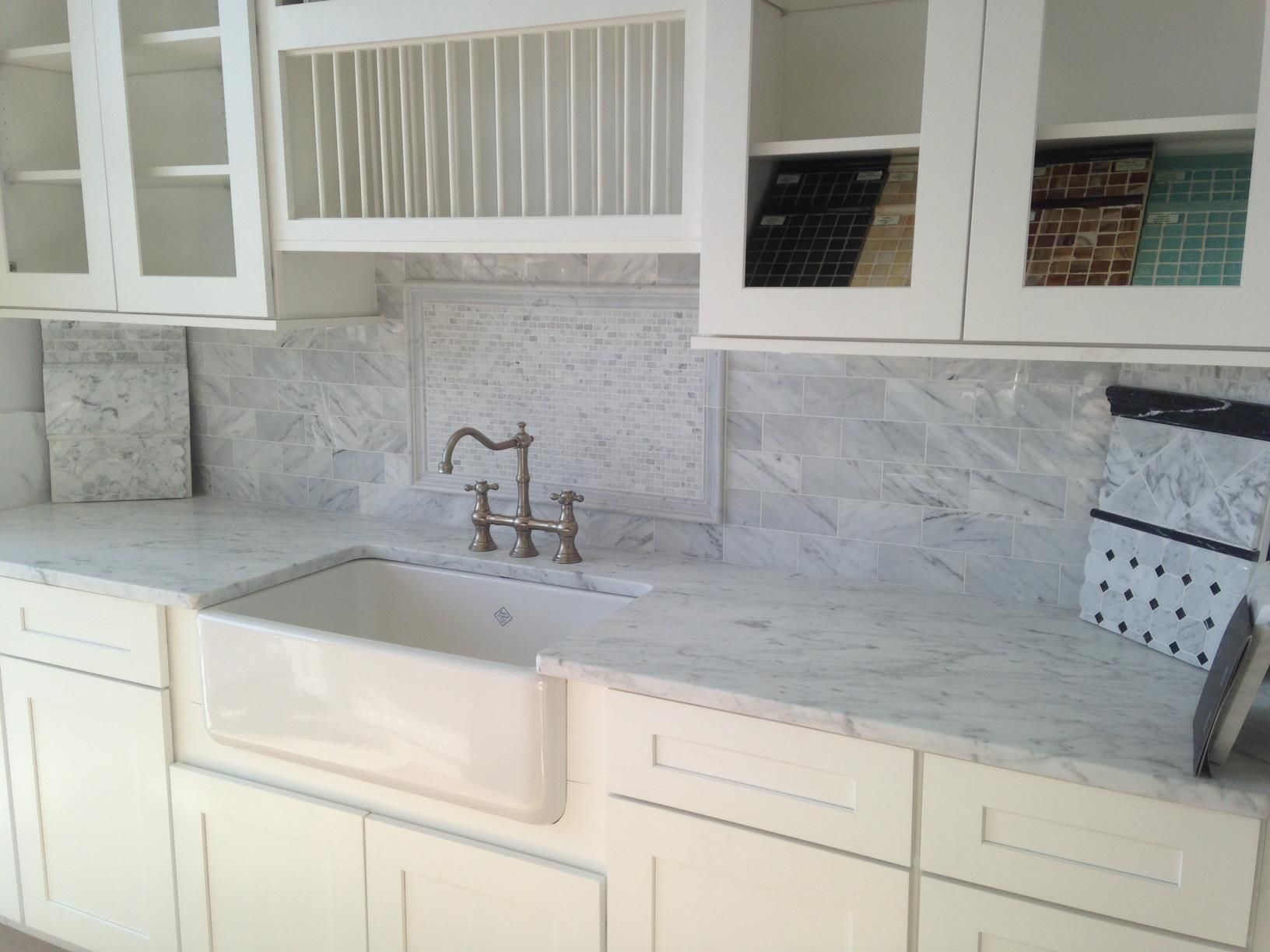 A kitchen with white cabinets and a white sink