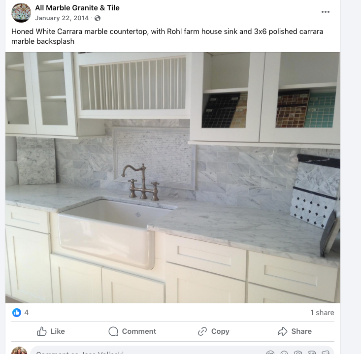 A picture of a kitchen with marble counter tops and a sink
