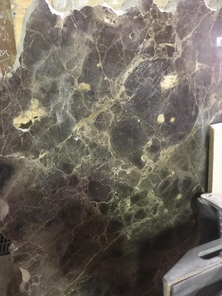 A close up of a marble wall next to a printer.