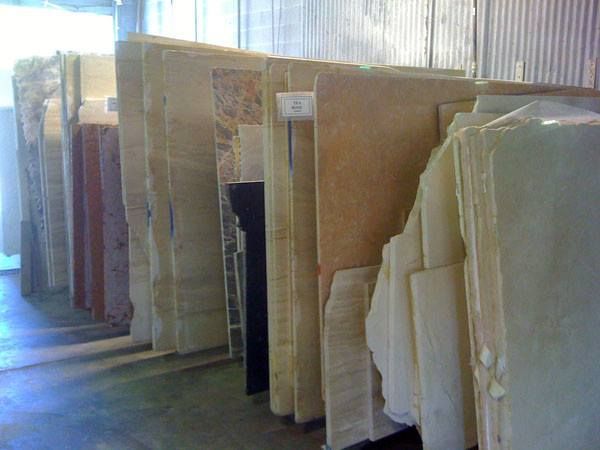 A warehouse filled with lots of different types of marble slabs.