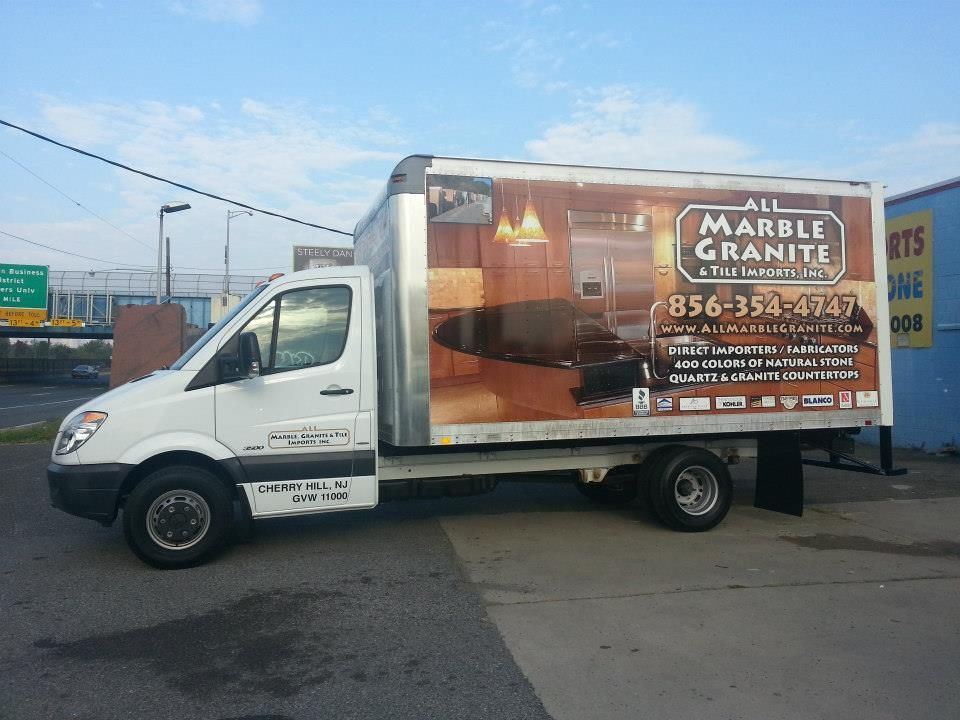 A marble granite truck is parked in a parking lot
