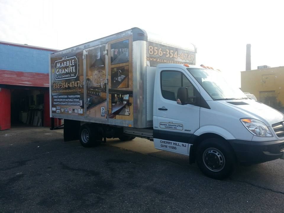 A marble granite truck is parked in a parking lot