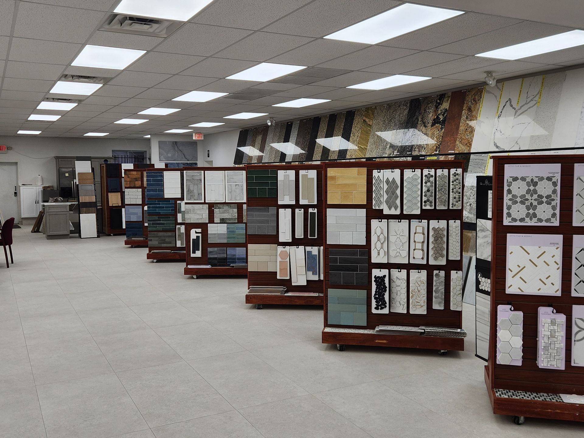 Tile showroom with display shelves featuring various tile samples under bright ceiling lights