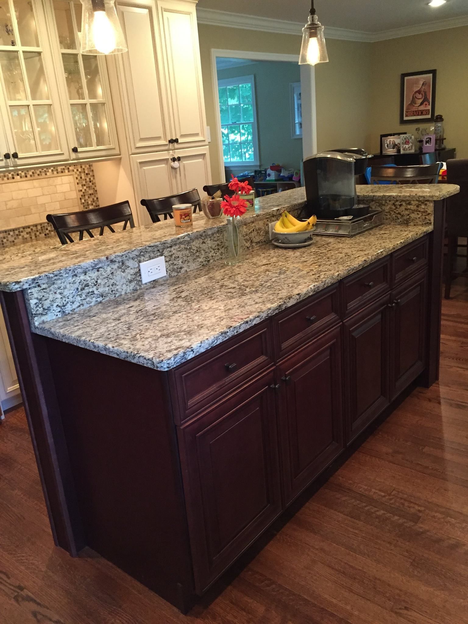 A kitchen with a large island and granite counter tops.
