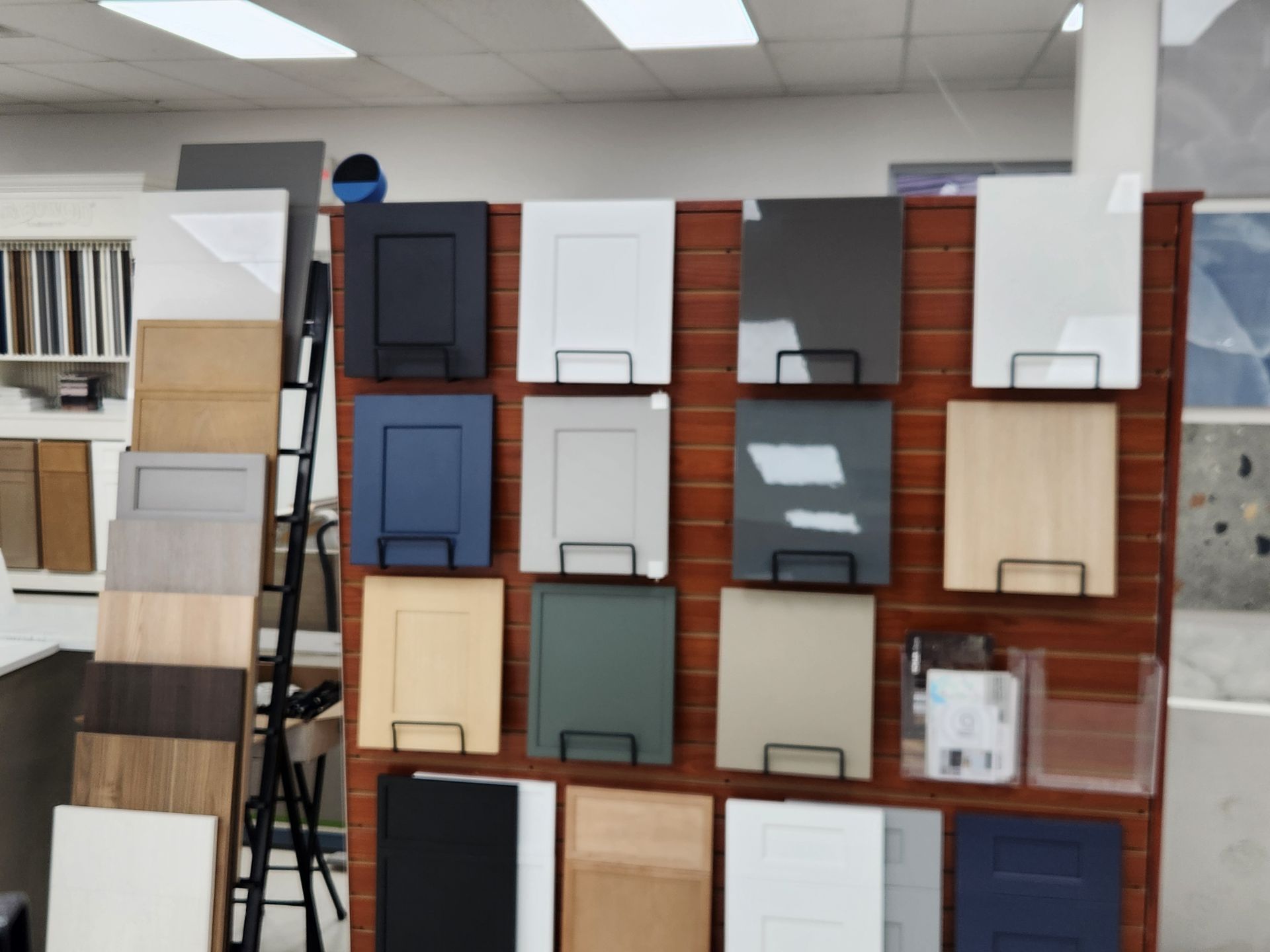 Cabinet door samples in various colors displayed on a wooden board