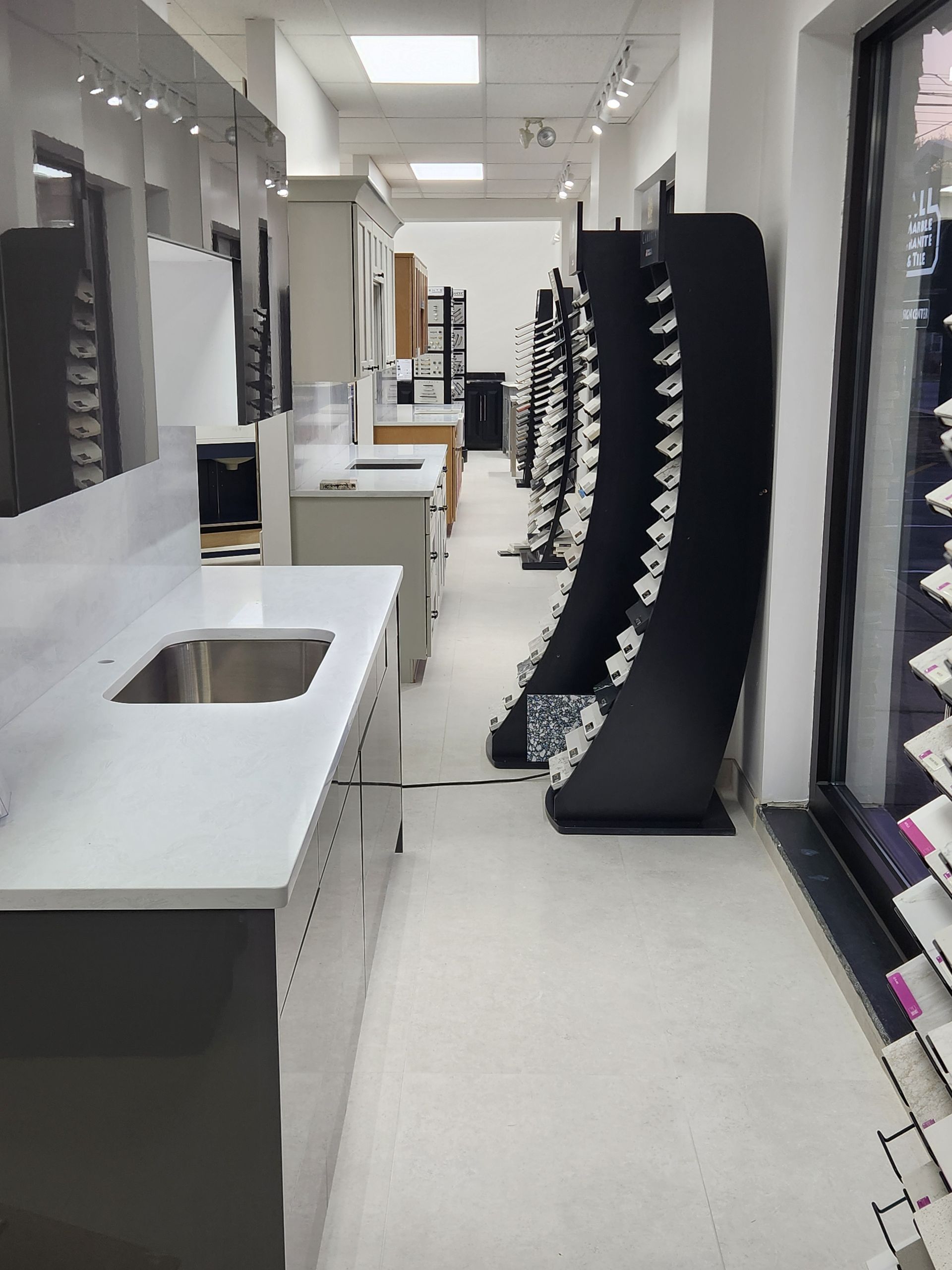 Interior of a showroom with countertops, displays of tiles, and bright lighting
