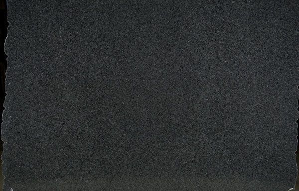 A close up of a black granite slab on a table.