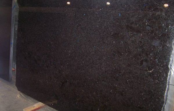 A large black granite slab is sitting on top of a wooden table.