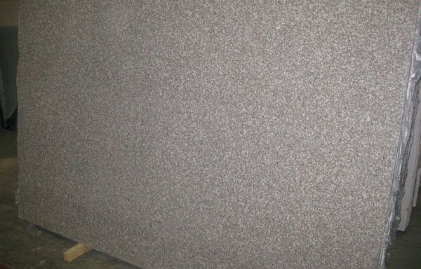 A large piece of granite is sitting on top of a wooden table.