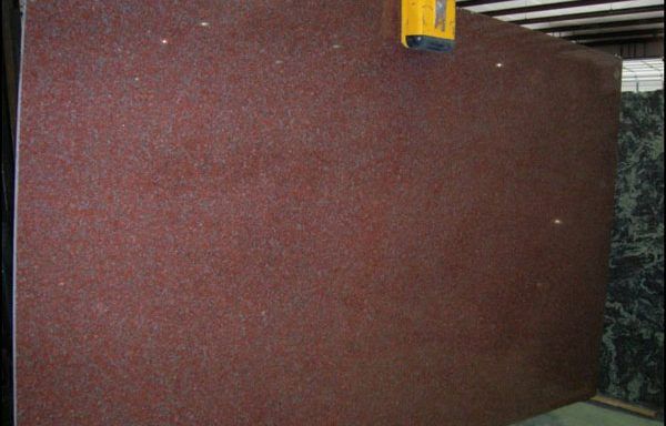 A large red granite slab is sitting on a table in a room.