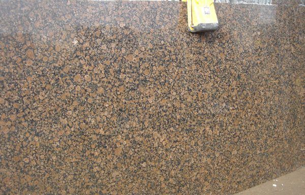 A close up of a brown granite counter top with a yellow ruler on it.