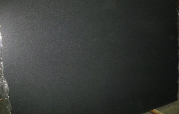 A black piece of paper is sitting on top of a wooden table.