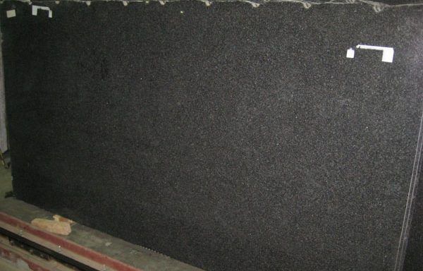A large black granite slab is sitting on top of a wooden table.