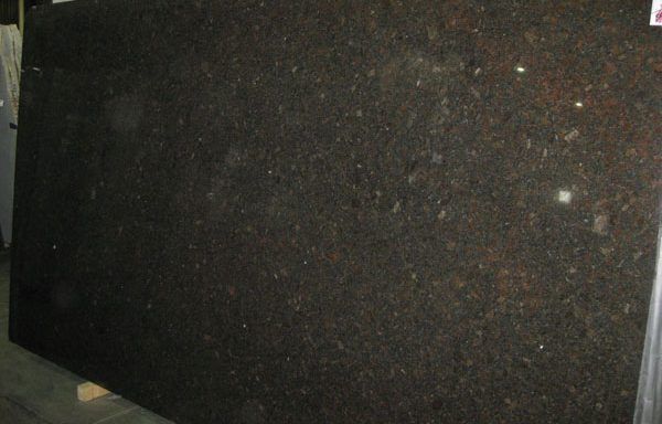 A large black granite slab is sitting on top of a wooden table.