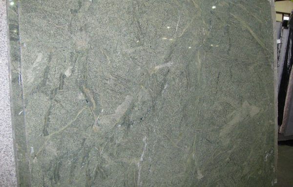 A close up of a green granite slab with a marble texture.