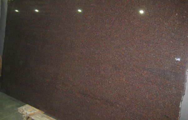 A large brown granite slab is sitting on top of a wooden pallet.