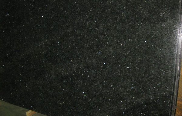A close up of a black granite counter top with white dots on it.