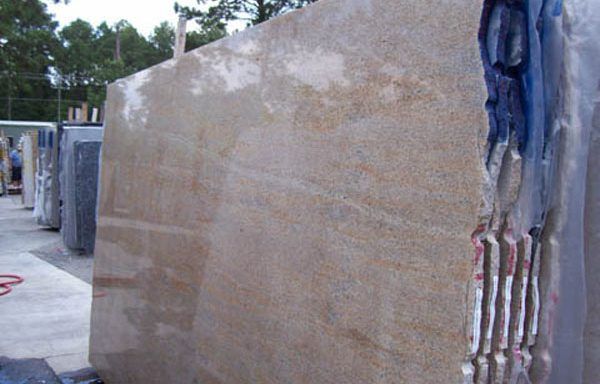 A large slab of granite is sitting on top of a concrete surface.