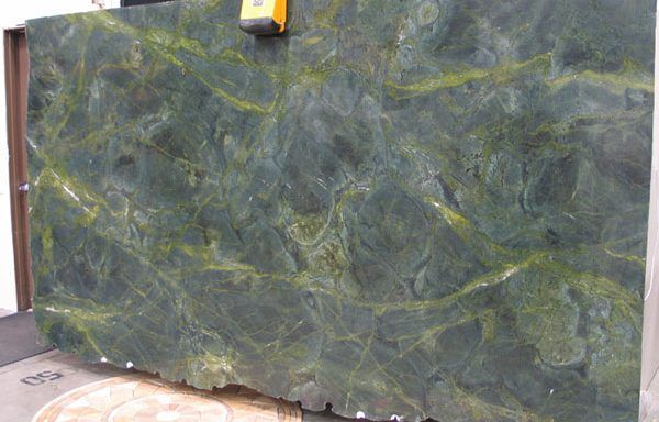 A green marble slab is sitting on top of a tiled floor.