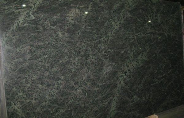 A large green marble slab is sitting on top of a wooden table.