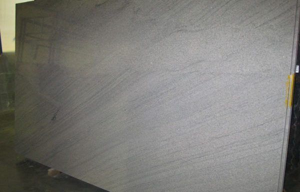 A large gray granite slab is sitting on top of a wooden table.