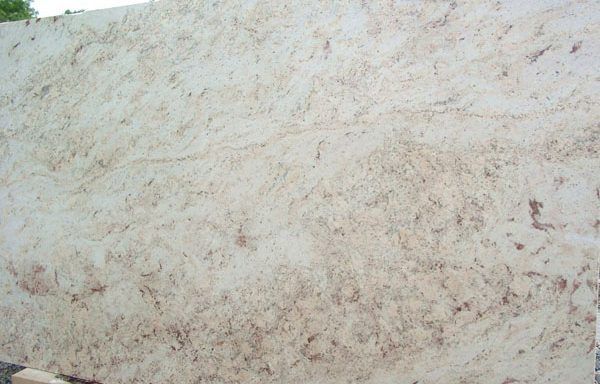 A close up of a white marble slab with brown spots