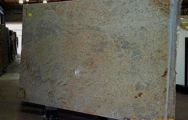 A large granite slab is sitting on a cart in a warehouse.