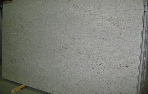 A large white granite slab is sitting on top of a wooden pallet.