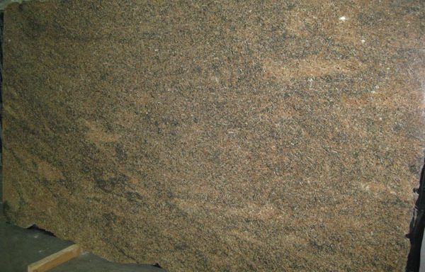 A large piece of brown granite is sitting on top of a wooden table.