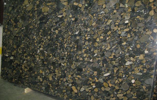A large piece of granite with a lot of rocks on it