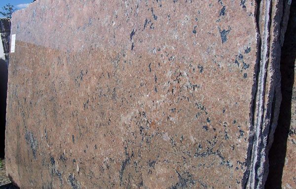 A stack of granite slabs are sitting on top of each other.