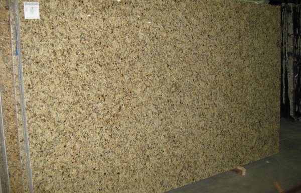 A large slab of granite is sitting on the floor in a warehouse.