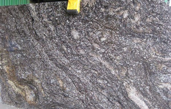 A close up of a piece of granite with a yellow tape measure on top of it.