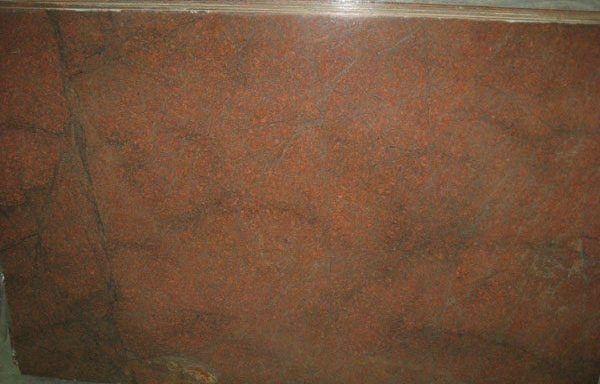 A close up of a red granite slab sitting on top of a table.