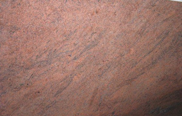 A close up of a red granite counter top