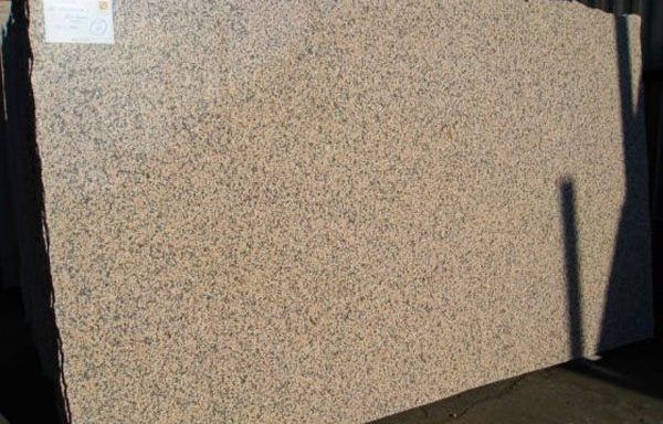 A large piece of granite is sitting on the ground.