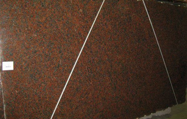 A large piece of red granite is sitting on top of a table.