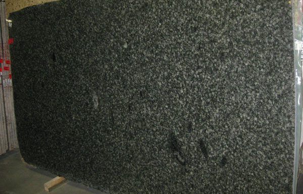 A large black granite slab is sitting on top of a wooden table.
