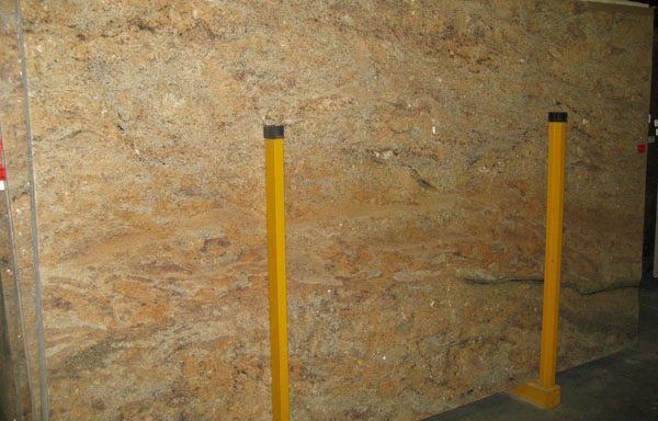 A large piece of plywood is sitting next to two yellow poles.