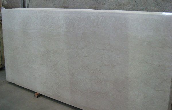 A large white slab of granite is sitting on top of a wooden pallet.