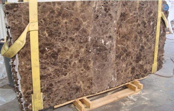 A large piece of brown marble is sitting on a wooden pallet.