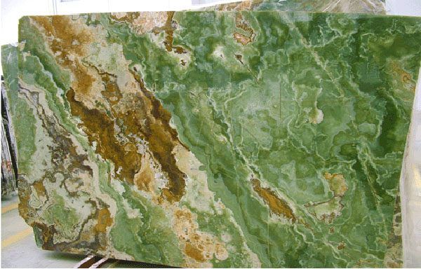 A piece of green and brown marble is sitting on a table.