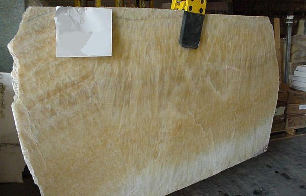 A large piece of marble is being lifted by a crane.