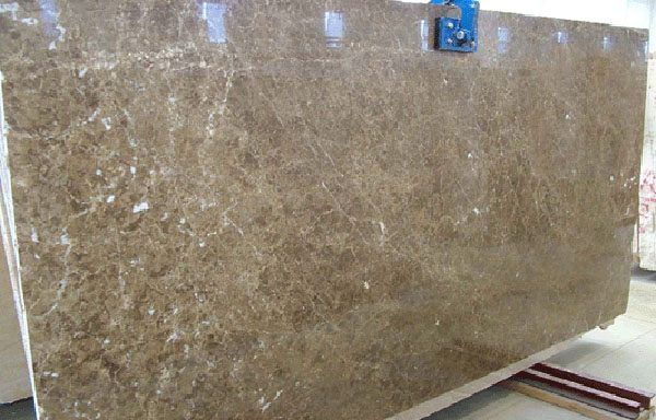 A large brown marble slab is sitting on top of a wooden table.