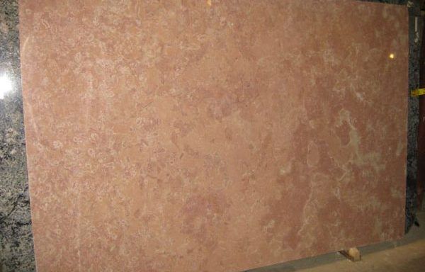 A large piece of pink granite is sitting on top of a table.